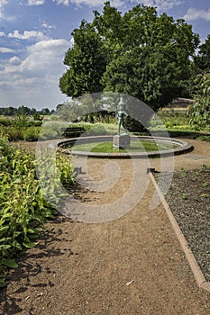 View of the statue, trees and flowers along a pathway at Rheinp