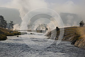 A view of steaming geysers from the river in Yellowstone National Park, Wyoming.