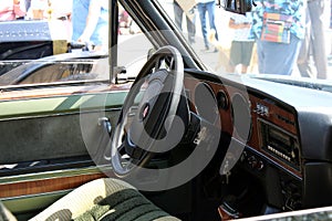 View of the steering wheel and cockpit dashboard in vintage style. Retro car.