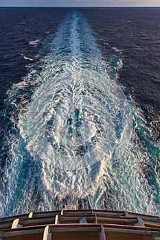 View of the stern of a cruise ship and the foam wake left by the propellers
