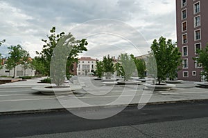 View on stone extra large planters for live trees in residential area.