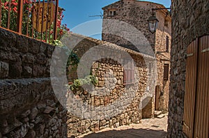 View of stone houses in a narrow alley under blue sky at Les Arcs-sur-Argens
