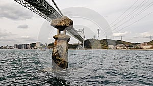 View of Stone lantern basket of Kazuki Kari Shrine and Kanmon Strait under gray sky in Japan