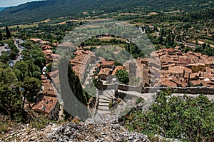 View of stone staircase, roofs and belfry under sunny blue sky in Moustiers-Sainte-Marie.