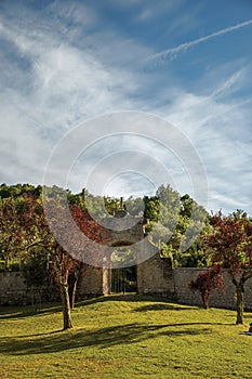 View of stone wall and gate at sunset amidst the vegetation in the Park of Bomarzo.