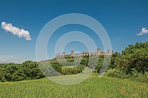 View of the stone walls of the hamlet of Monteriggioni on top of hill.