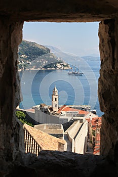 View through a stone window to the Dubrovnik harbor with a sailing boat in the background, Dalmatia region of Croatia