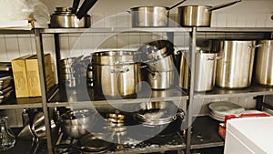 View of storage rack with various pans in restaurant kitchen