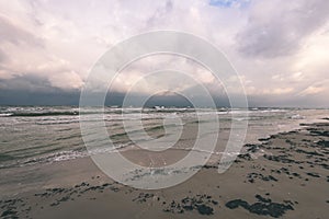 View of a stormy beach in the morning. - vintage film look