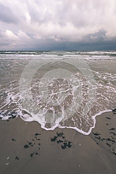 View of a stormy beach in the morning. - vintage film look