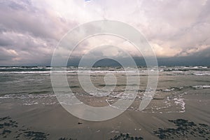 View of a stormy beach in the morning. - vintage film look