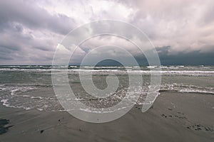 View of a stormy beach in the morning. - vintage film look