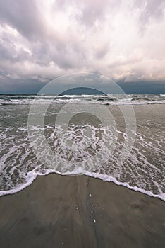 View of a stormy beach in the morning. - vintage film look