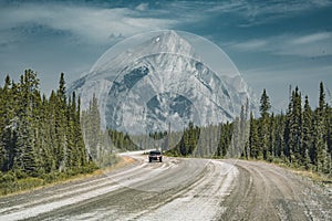 View of street highway with mountains and trees with blue sky and clouds. Banff National Park Canada Rocky Mountains.