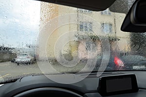 View on street from modern car windshield with rain drops, closeup