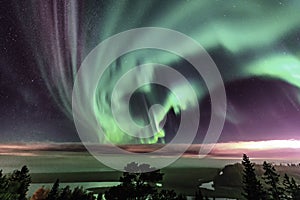 View of Strong Northern Lights and atmospheric phenomenon `STEVE` meets Milky Way. Steve appears as a purple and green light photo