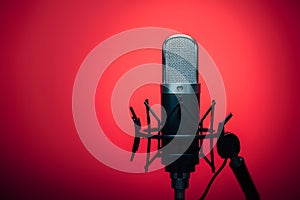 view Studio podcast microphone on gradient red background, broadcasting equipment photo