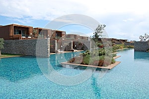 View of the stylish villas, blue pool and flower beds in luxury