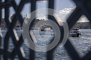 View of suleymaniye mosque among the railings on Galata bridge, passengers and fishing boats, to the view of Istanbul