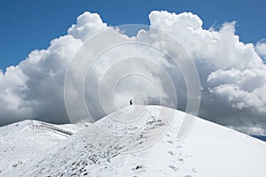 View of the summit of Monte Calvo against a big cloud and blue sky photo