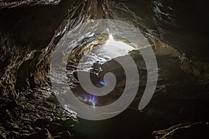 View into the sun out of Luxmore cave on the Kepler Track, one of New Zealand`s Great Walks