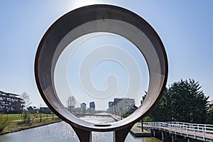 View on a sunny day on the Heem Kanaal in Zoetermeer through a round work of art, Netherlands