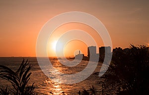 View of the sunset on the beach bar with the Barra Lighthouse in the background photo