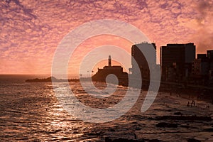 View of the sunset on the beach bar with the Barra Lighthouse in the background photo