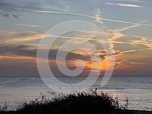 A view of a Sunset on the beach at Siesta Key, Florida with a blue cloudy sky