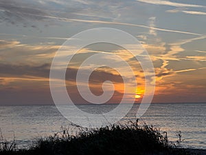 A view of a Sunset on the beach at Siesta Key, Florida with a blue cloudy sky