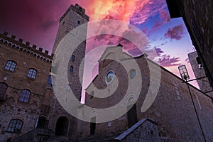 view at sunset of the big tower and town hall of the town of san gimignano in tuscany