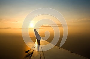 View of the sunset,clouds and airplane wing from the Inside