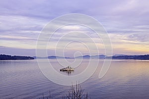 View of the sunset at the ocean with small boat in Vancouver Island, Canada