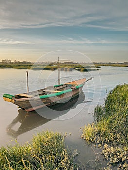 View of sunset on Ria de Aveiro with a typical fishing boat, Ovar, Portugal photo