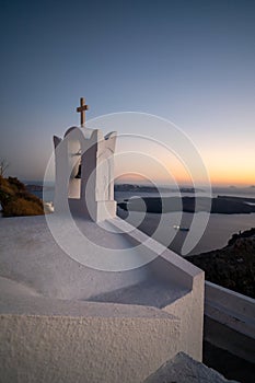 View of the sunset in Santorini with a Christian Greek Orthodox church with a bell tower