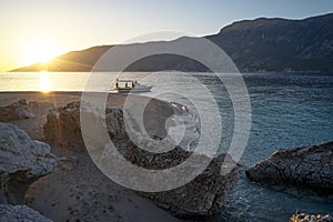 View of sunset sea and the beach with rocky cliffs.