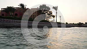 View of the sunset on the water canals of the city. The camera removes from the moving boat.