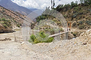 View of the suspension bridge and the Santa river on the road to Pavas in the afternoon. Caraz