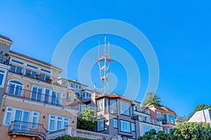 View of Sutro Tower above the large residential house buildings in San Francisco, CA