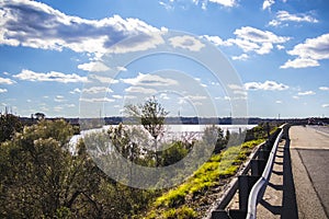 A view of a swamp and highway clouds and blue sky