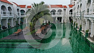 View of swimming pool inside the hotel. Green color of swimming pool at the sunny day