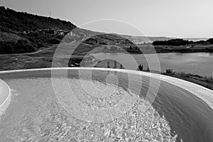 View on swimming pool, lake and sea at Thracian Cliffs resort in black and white