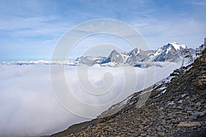 View of Swiss Alps over clouds on a sunny day