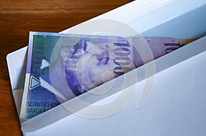 View of the Swiss francs currency on the mailer