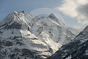 View of the Swiss mountains in winter. Mittelhornin clouds, Schreckhorn and Wetterhorn. Swiss alps in Switzerland Jungfrauregion