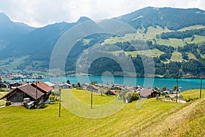 View of swiss village Lungern with traditional houses along the lake Lungerersee, canton of Obwalden, Switzerland.