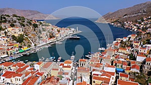 View on Symi Simi island harbor port, classical ship yachts, houses on island hills, Aegean Sea bay. Greece islands holidays