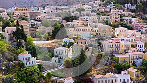 View on Symi Simi island harbor port, classical ship yachts, houses on island hills, Aegean Sea bay. Greece islands holidays