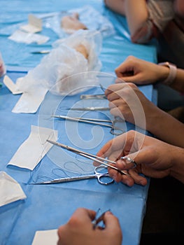 View on table with blue cover and surgical instruments during surgical suturing course