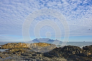 View of Table Mountain with clouds in sky, from Blouberg beach in Cape Town